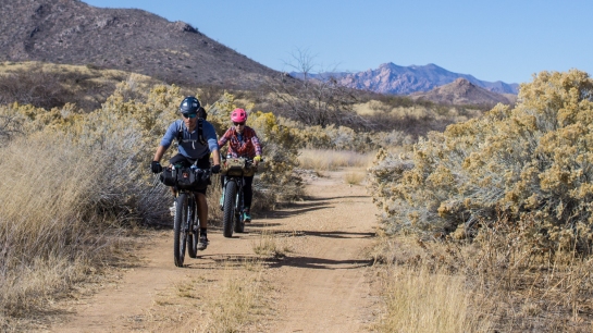 Kody and Jenny roll through another road lined with cottony desert brush.